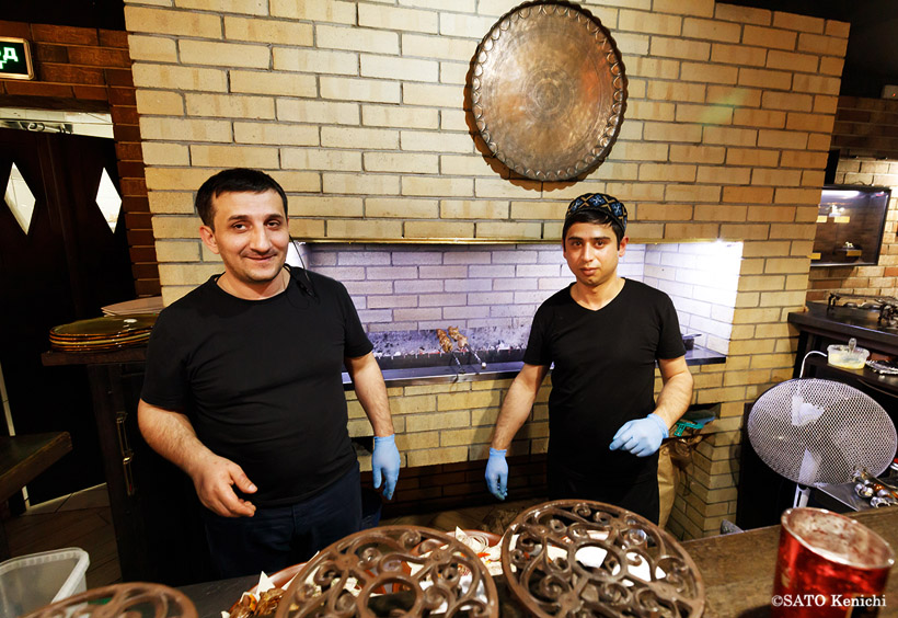 彼らはオープンキッチンの厨房でシャシリクを焼く中央アジア系の調理人たち